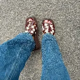 Zuecos con plataforma marrón y capellada tejida en damero blanco y marrón.