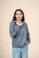 Cárdigan gris de tejido de punto acanalado, con cuello alto, cierre de cremallera corto y corte holgado.