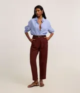 Pantalón zanahoria de cintura alta color borgoña, con trabillas, pliegues y cinturón fino de cuero sintético.