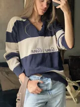 Sweater de hilo de algodón a rayas horizontales rosas y grises, con cuello polo, botones de guampa y bordado de Sierra Mora a tono.