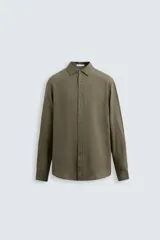 Camisa de hombre color verde oliva, corte regular, confeccionada en tejido de lino. Tiene cuello solapa, manga larga con puños abotonados y cierre frontal con botones.