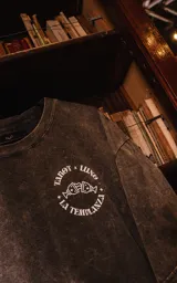 Remera gris nevado de manga corta y cuello redondo, con calce oversize y estampado sublimado con la leyenda "Tarot x Luxo La Templanza" y un diseño de copas.