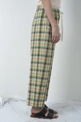 Pantalón de lino a cuadros en tonos verdes y marrones, con cintura elástica y cordón ajustable.