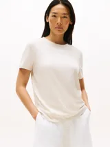 Remera de algodón color crema con cuello redondo y logo de Tommy Hilfiger estampado en el pecho.