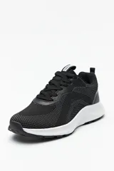 Zapatillas deportivas negras de tela transpirable con cordones a tono y suela blanca de 3cm de alto.