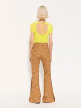 Pantalón flare color camel de broderie con aberturas en botamangas cerradas con broches dorados. Presenta bolsillos delanteros diagonales con vivos en cuero al tono.