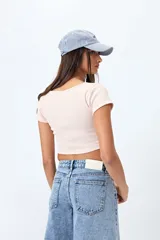 Top corto color amarillo, de mangas cortas y escote redondo.