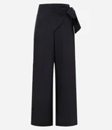 Pantalón pantalona de sastrería color negro, confeccionado en tejido texturizado. Presenta corte amplio, superposición lateral con lazo y tiro alto.