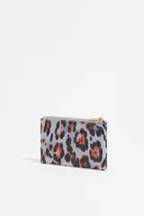 Monedero Bimba y Lola con estampado animal print en tonos lila, negro y naranja. Cierre con cremallera dorada y logo de la marca en dorado.