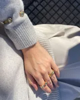 Anillo dorado con diseño de tres bandas entrelazadas.
