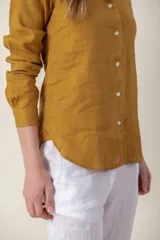 Camisa de manga larga color mostaza, confeccionada en lino.