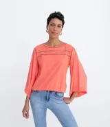 Blusa color salmón con escote redondo, mangas 3/4 amplias y ajuste frontal. Confeccionada en tejido laise.