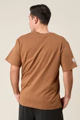 Remera blanca de algodón con estampado frontal que incluye el texto "The Boston Est. 1997" y un texto vertical más largo en el lateral.