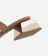 Sandalia mule color beige con dos tiras, puntera cuadrada y tacón bajo cuadrado cromado.