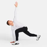 Remera deportiva blanca de manga larga, ajustada al cuerpo, con tecnología Dri-Fit y logo de Nike en el pecho.