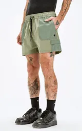 Short de baño verde militar con calce regular, cuatro bolsillos, elástico en la cintura y cordón para ajustar. Confeccionado en tejido plano liviano de secado rápido.