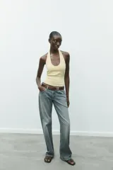 Top color crema con cuello halter y escote redondo. Espalda descubierta.