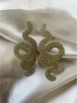 Par de aros colgantes con forma de serpiente, color negro con glitter. Cierre a presión de acero inoxidable.
