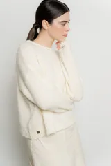 Sweater de punto color crudo, de corte holgado y mangas largas.