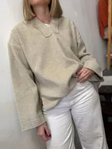 Buzo canguro beige de paño con capucha y mangas largas.