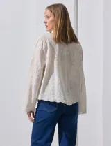 Camisa de manga larga color beige, con bordado tipo broderie, cuello con solapa y abertura central con botones.