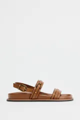 Sandalias planas color marrón con doble tira delantera con detalle de hebilla y cierre mediante hebilla en la pulsera al tobillo.