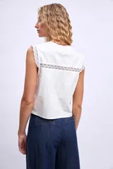 Chaleco blanco con escote en V, detalle de encaje y lazos en el frente.