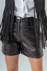 Short de cuero negro con cintura alta, cierre frontal con botón y bolsillos laterales.