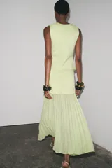 Chaleco color verde claro de punto con escote pico y cierre frontal con botones dorados.