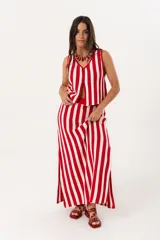 Sandalia baja color rojo de cuero con agarre trasero con hebilla y detalle de tachas de distintas medidas en la capellada.