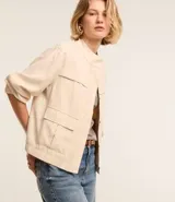 Campera bomber negra de viscosa con cierre delantero, bolsillos con solapa y pespuntes contrastantes en color blanco.