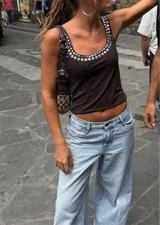 Musculosa corta marrón con cuello redondo y apliques metálicos plateados alrededor del escote.