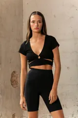 Crop top celeste de tejido de punto acanalado, con escote en V y detalle de abertura circular en el centro.