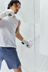 Short deportivo celeste a media pierna, confeccionado en tejido funcional DryMove™ que absorbe el sudor. Cuenta con cintura elástica con cordón ajustable, bolsillos laterales con cierre, orificios de ventilación cortados a láser y abertura lateral en el bajo.