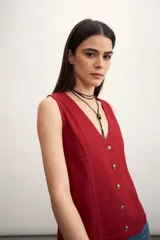 Chaleco negro con escote en V y abotonadura frontal.