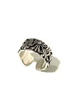 Anillo plateado con diseño floral y acabado envejecido.