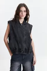 Chaleco denim negro con fit relajado y hombros caídos.