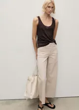 Pantalón de jean color beige, de corte wide leg, tiro medio y bolsillos de parche frontales.
