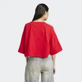 Remera roja Adidas de corte boxy y mangas anchas con tres tiras blancas en los hombros.