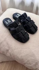 Sandalias bajas color rosa viejo con tiras de cuero entrelazadas y suela marrón.