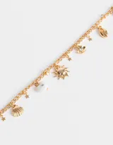 Collar corto dorado con cadena de eslabones y dijes colgantes de sol, conchas marinas, estrellas, corazón, flor y cuentas.
