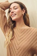 Sweater blanco de tejido calado con diseño en forma de espiga, escote redondo y mangas largas.