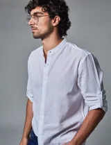 Camisa blanca de lino con cuello mao y mangas largas con presilla para enrollar.
