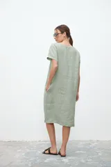 Vestido midi verde claro de lino, corte recto, cuello en V y mangas cortas.