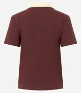 Blusa blanca acanalada de rib con cuello polo negro contrastante y mangas cortas.