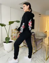 Pantalón de jogging negro de algodón con cintura ajustable y estampado de un corazón rojo con la palabra "LOVE" en una pierna.