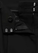 Pantalón negro de vestir, de tiro medio y corte recto.