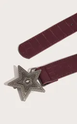 Cinturón color borgoña con textura símil cuero de cocodrilo y hebilla metálica con forma de estrella.