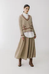 Falda midi color beige de tejido de punto acanalado, corte evasé y cintura alta.