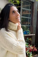 Sweater tejido a mano en lana merino color crema, con cuello alto tipo polerón y mangas largas.